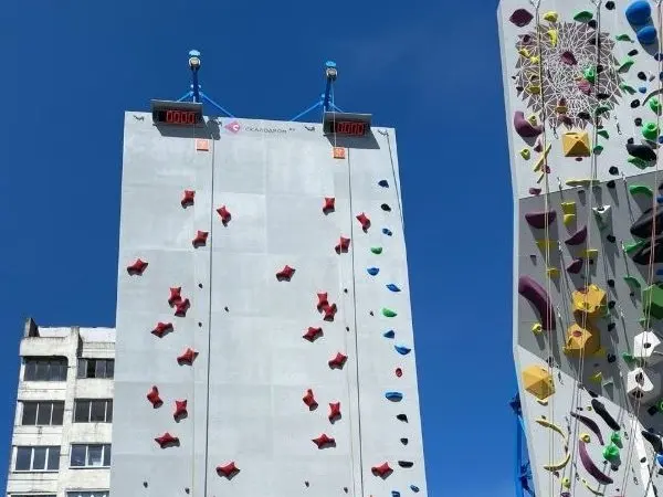 Speed lane with red holds and timing boards at the top, beside the lead wall
