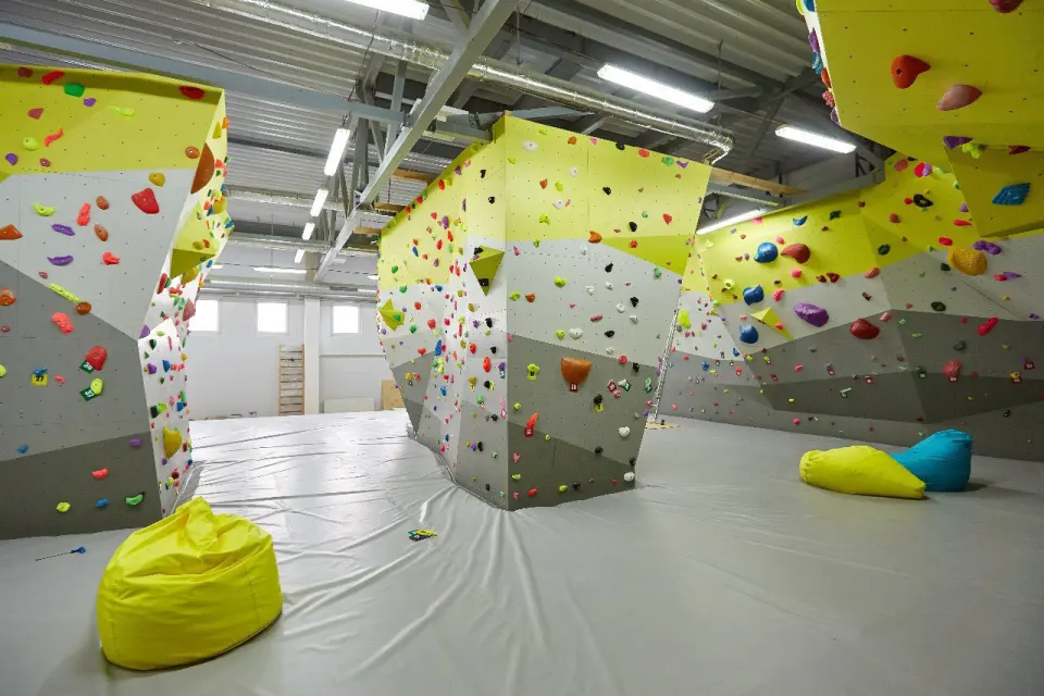 Freestanding bouldering blocks above thick grey matting in Trapezia's hall in Minsk