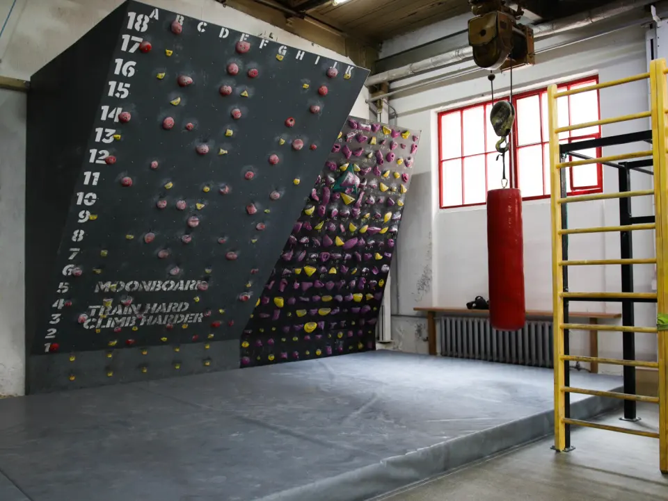 The MoonBoard and a steep training wall above thick matting at Plato in Minsk