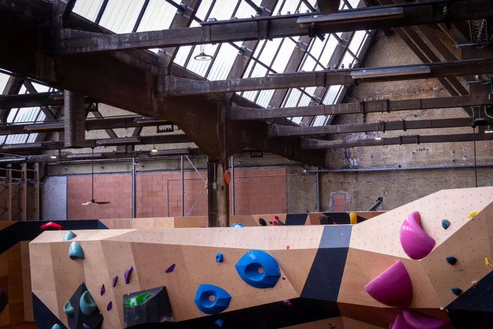 Plywood bouldering walls under the old railway hall's timber roof and skylights