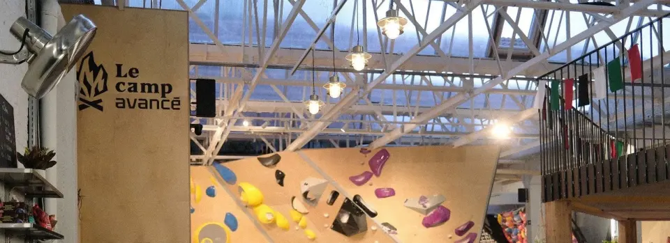 The hall under its glass roof, with the Le Camp Avancé sign beside an overhanging wall