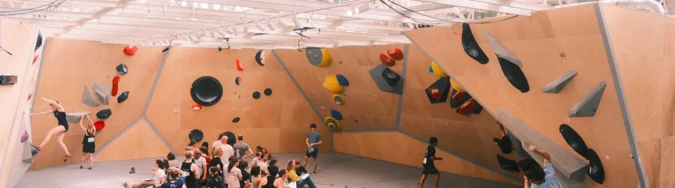Competition-style walls with large volumes, with climbers and spectators during an event