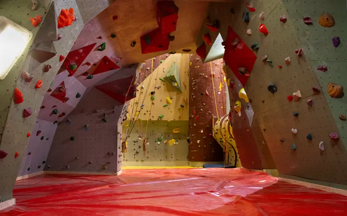 Overhanging section above red matting, with the roped walls beyond