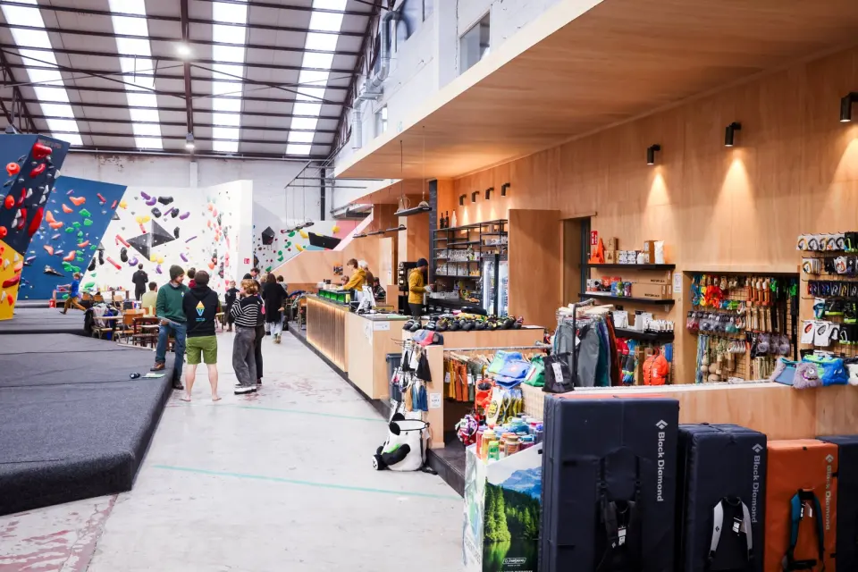 The bar and gear shop along one side of the hall, with bouldering walls behind