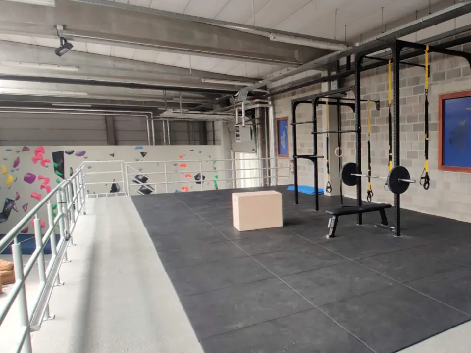 Fitness zone on the mezzanine with a rig, rings, barbell, bench and plyo box
