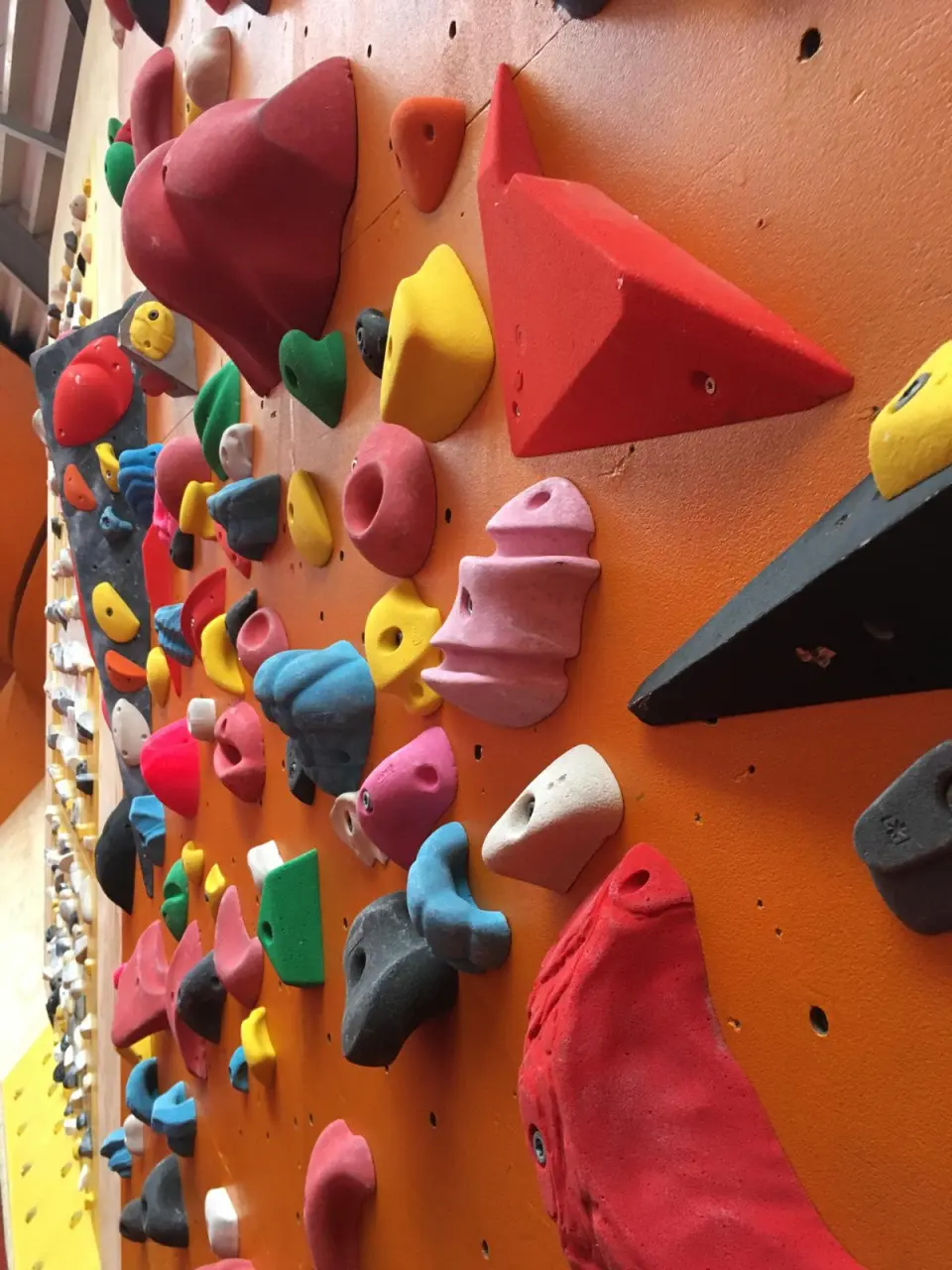 Close-up of colourful holds and volumes on an orange wall