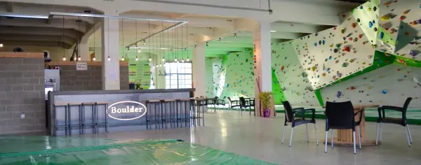 Bar with stools and tables beside the bouldering walls