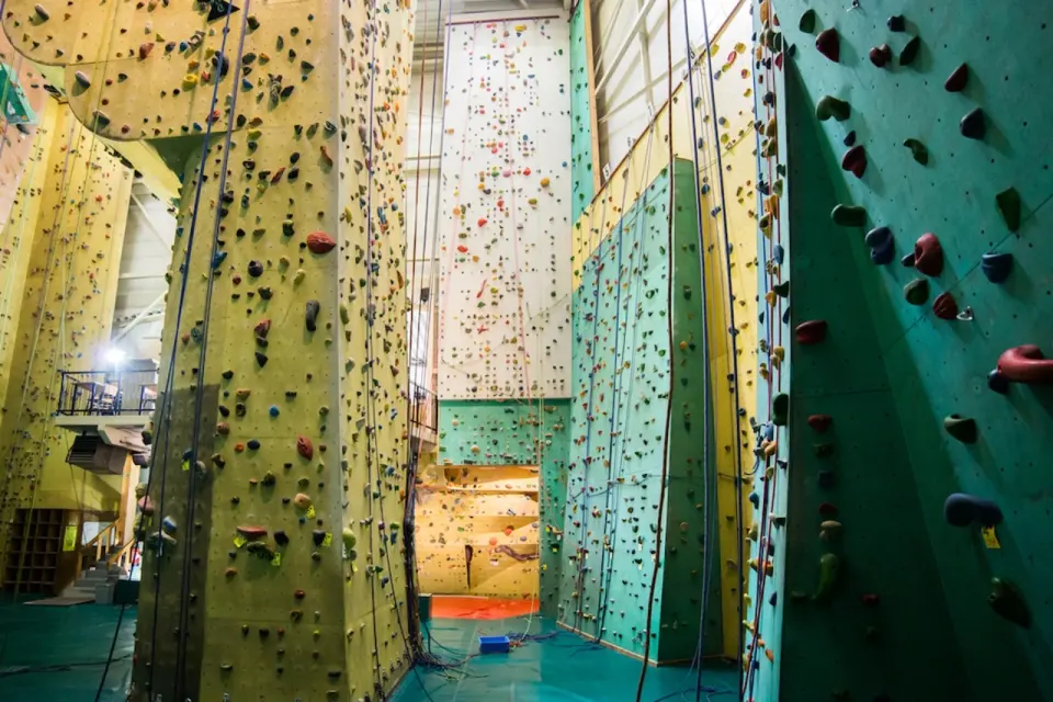 Tall roped walls around the central pillar, with the bouldering area at the far end