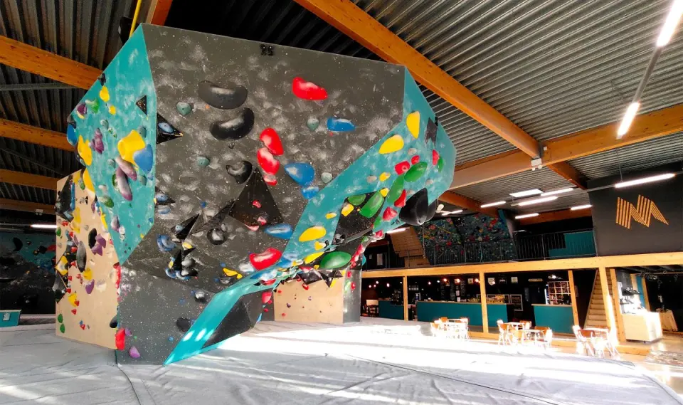 Freestanding grey and turquoise boulder in the hall, with the café and bar behind