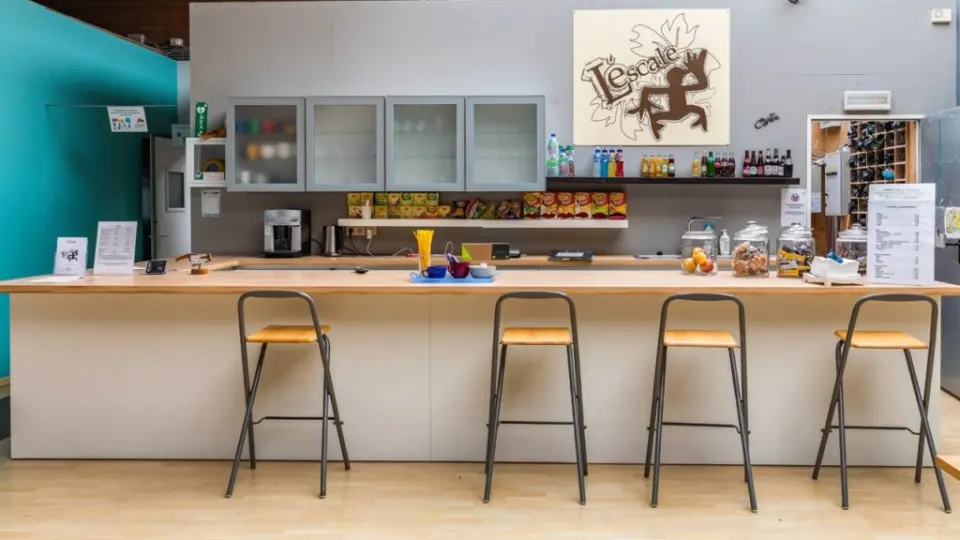 The bar counter with stools under the L'Escale logo