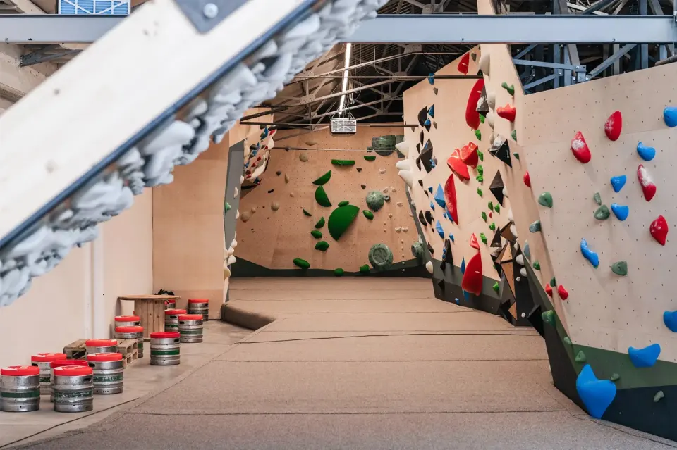 Plywood bouldering walls with red, blue and green holds at Onyx Boulder in Bruges