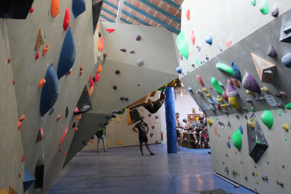 Bouldering walls with colourful holds under the old warehouse roof at L'Éléphant in Liège