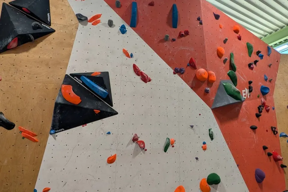 Freshly set problems on orange and white walls with large volumes at Dock 79 Bouldering near Mons