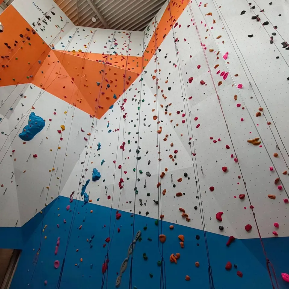 Orange overhanging bands above white and blue faces hung with ropes