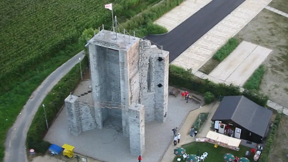 Aerial view of the grey block climbing towers beside the club chalet and a lawn with parasols