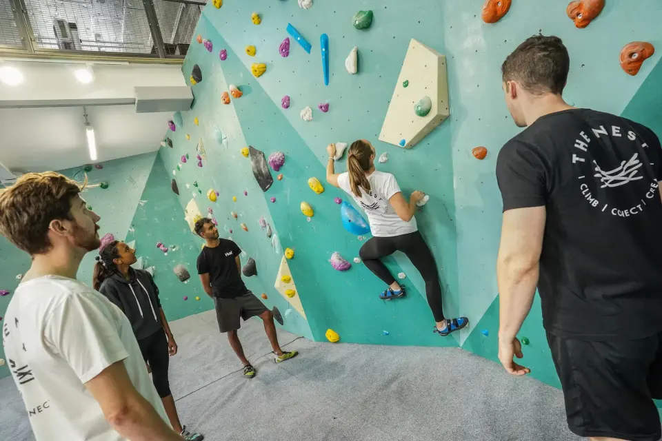 Climbers watching a boulderer on the main wall