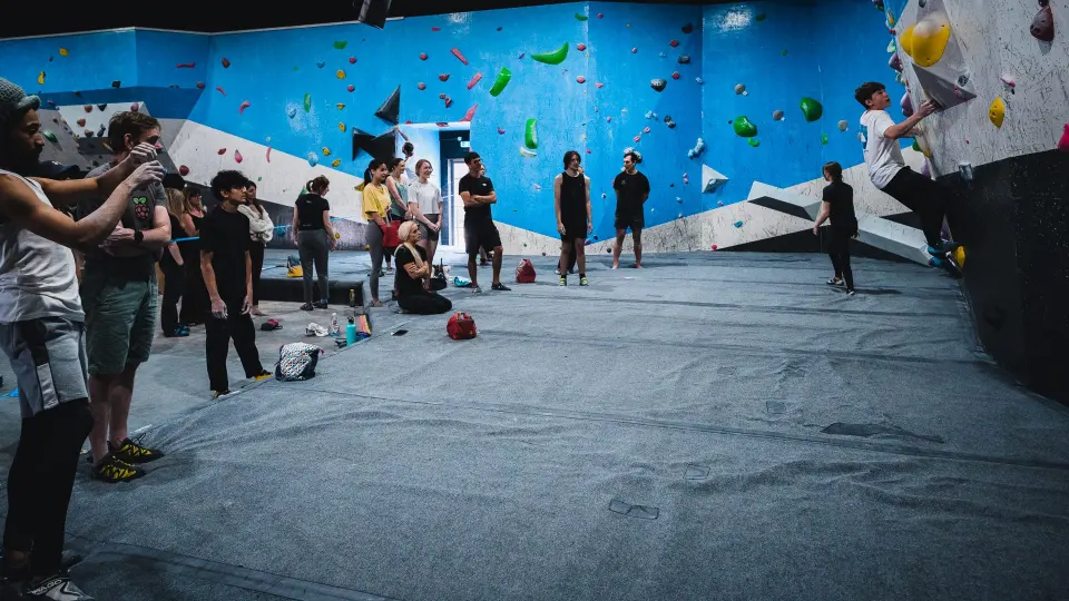 Climbers gathered on the matting in front of the bouldering wall