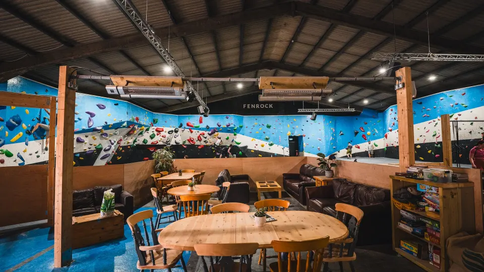 Café tables and sofas beside the bouldering walls