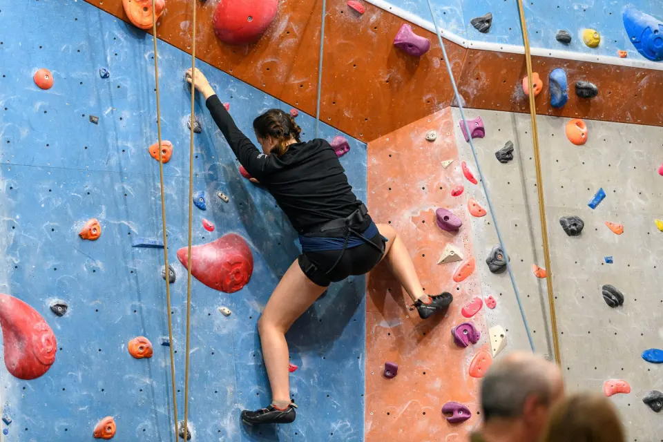 Climber reaching across an arete between two wall panels