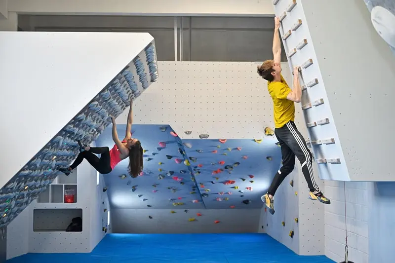 Climbers on the Kilter Board and campus board