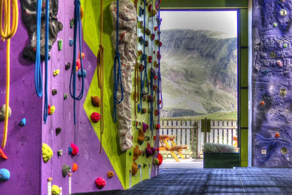 Purple and green walls with ropes, beside open doors looking out to the fells