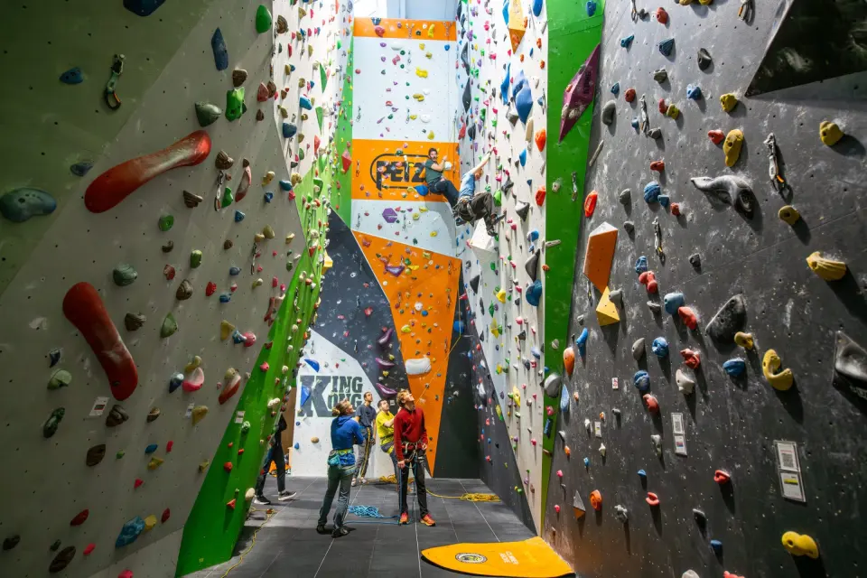 Tall roped walls with green and orange panels rising to the roof
