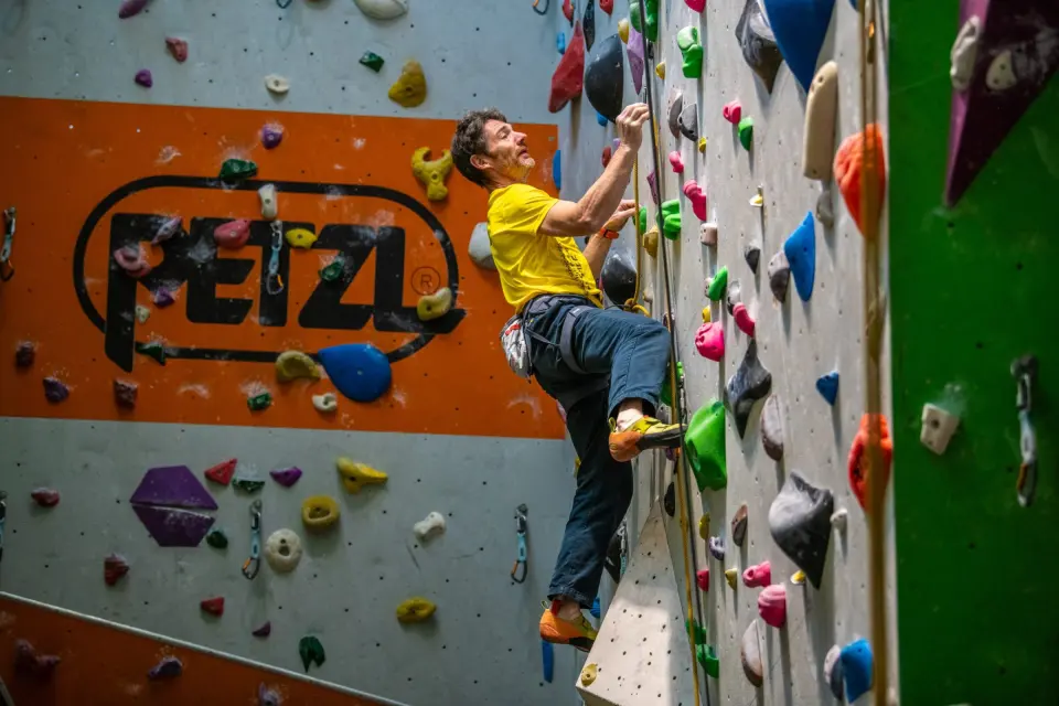 Climber leading past an orange panel