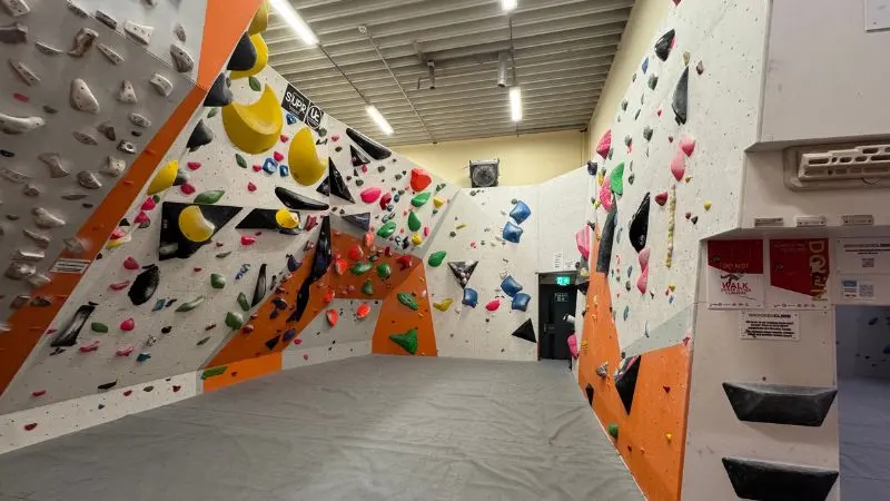 Bouldering area with freshly set problems above grey matting
