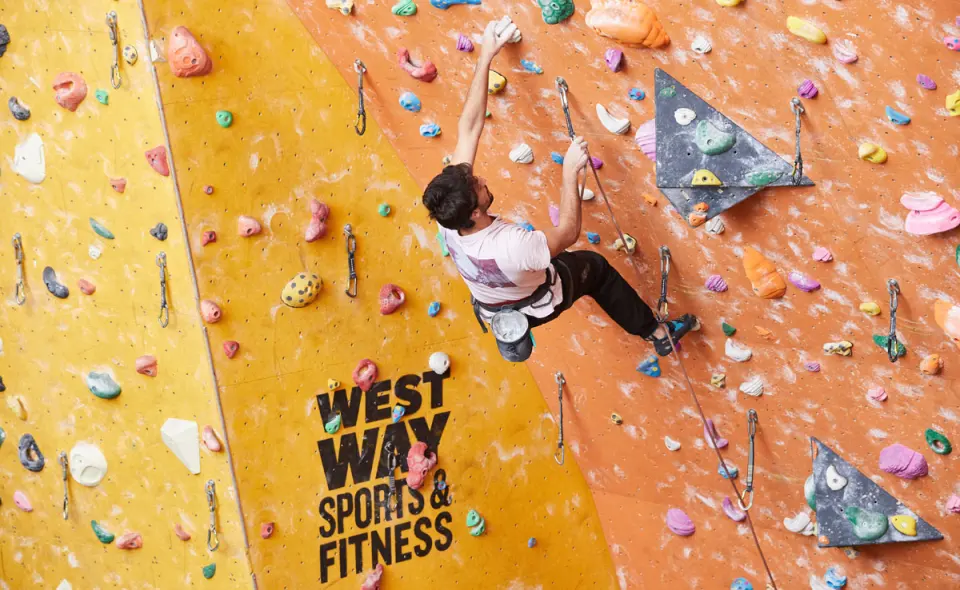 Lead climber clipping on the orange and yellow walls