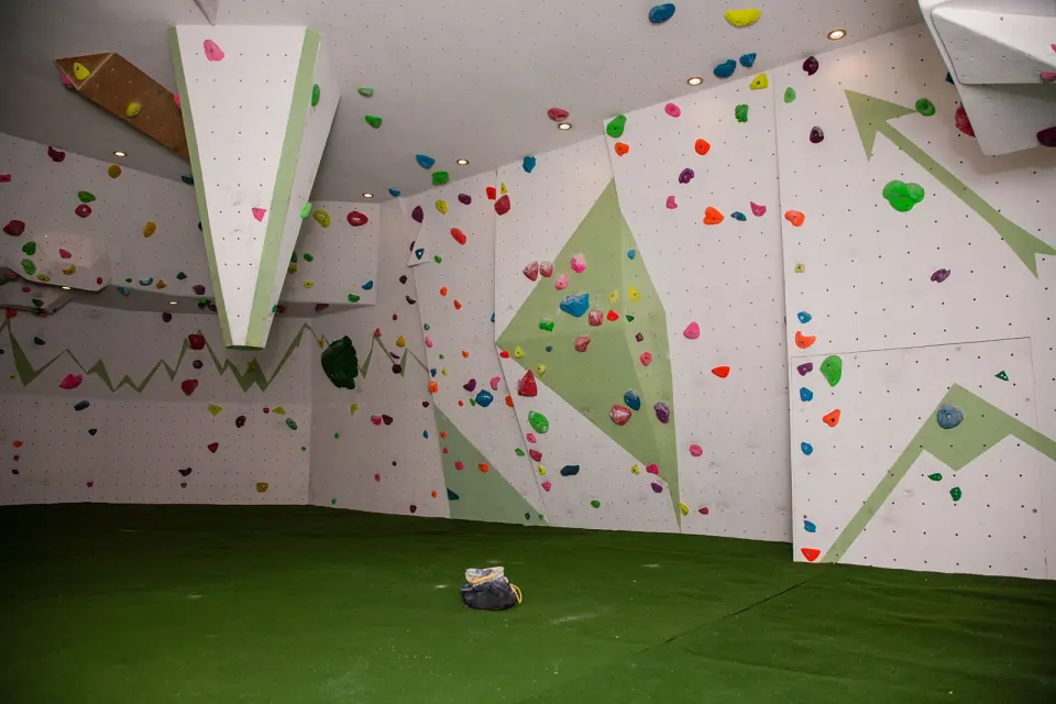 Bouldering room with angled walls and green matting