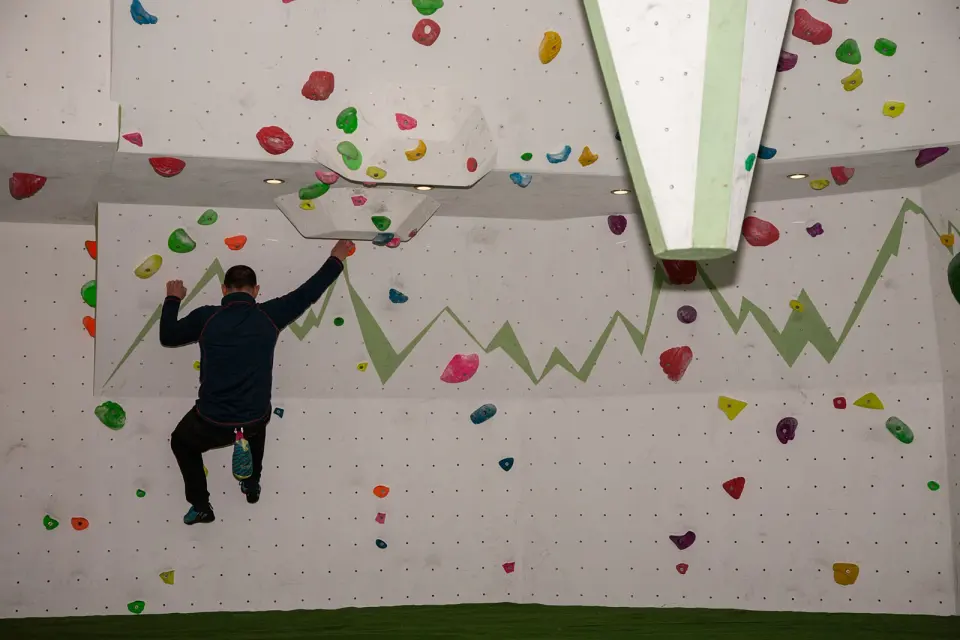 Climber reaching up under a bouldering roof