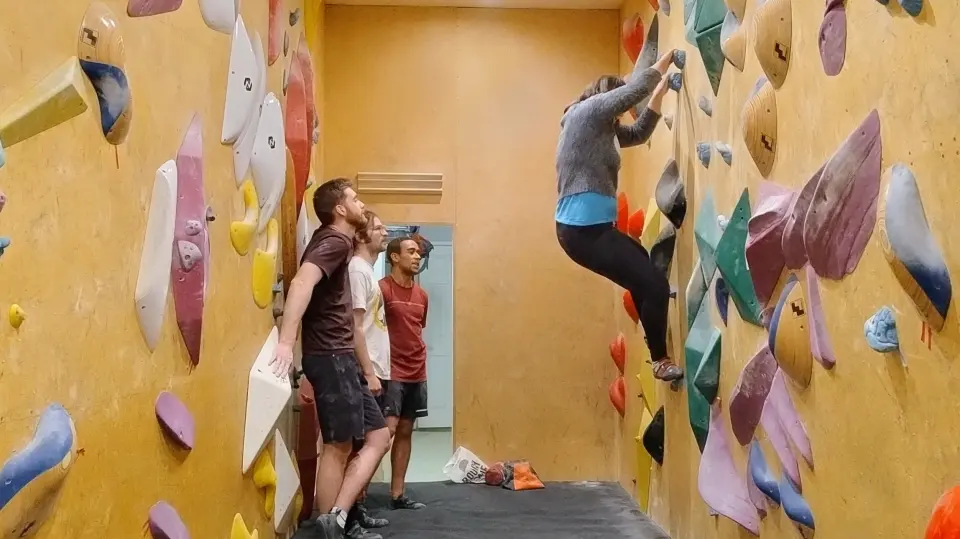 Climber on the steep wall of the narrow bouldering room