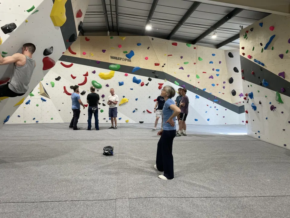 Bouldering walls with a long overhanging band and grey matting
