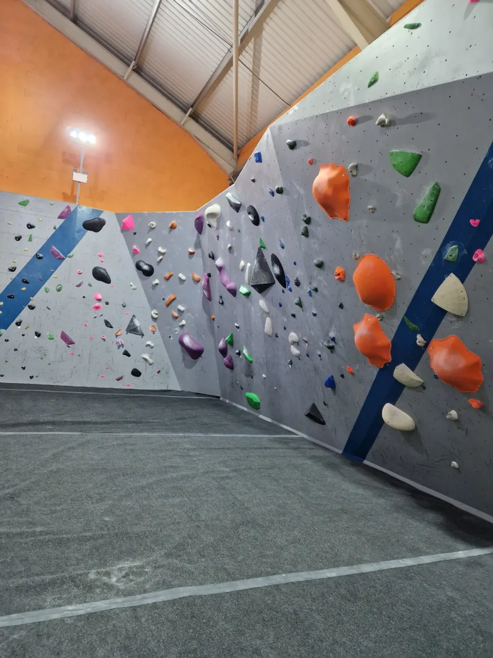 Corner of the bouldering room with orange and green volumes