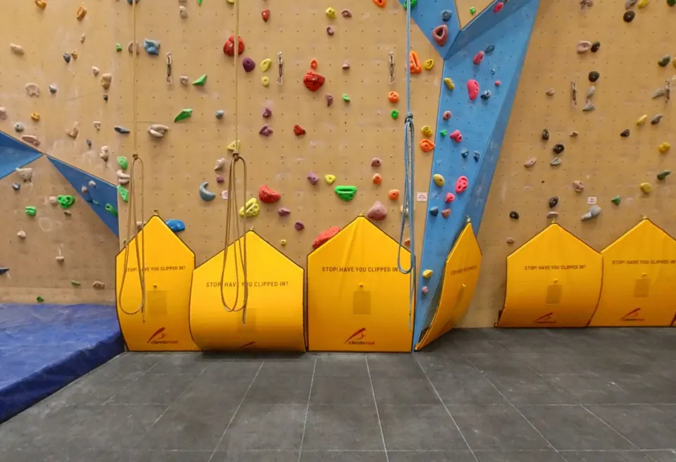 Roped climbing lines with rope bags at the foot of the wall