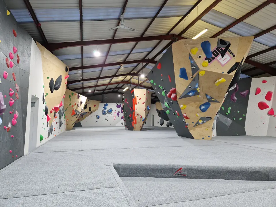 Bouldering hall with freestanding feature walls and grey matting