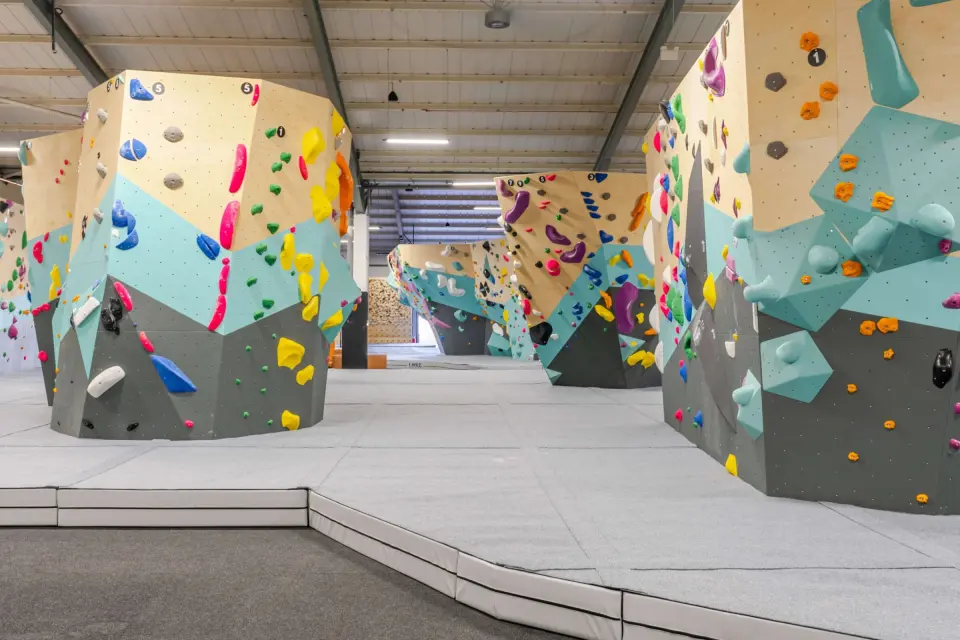 Freestanding bouldering towers over deep grey matting