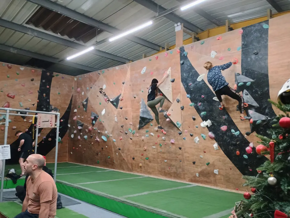 Climbers on the plywood walls beside the pull-up rig