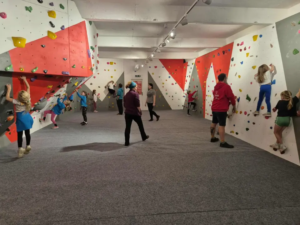 Climbers on the red, grey and white bouldering walls