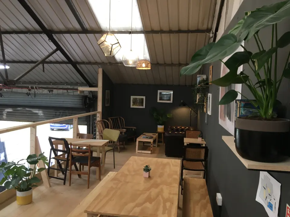 Café mezzanine with wooden tables and plants