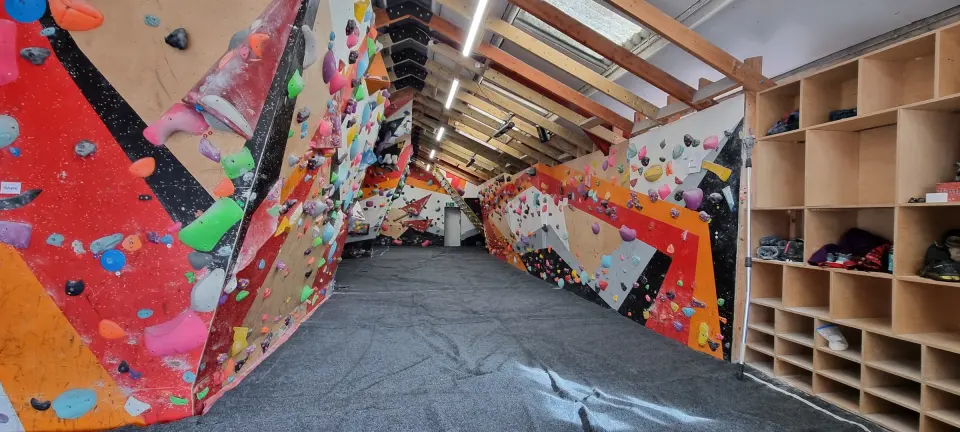 Long bouldering room with colourful walls along both sides