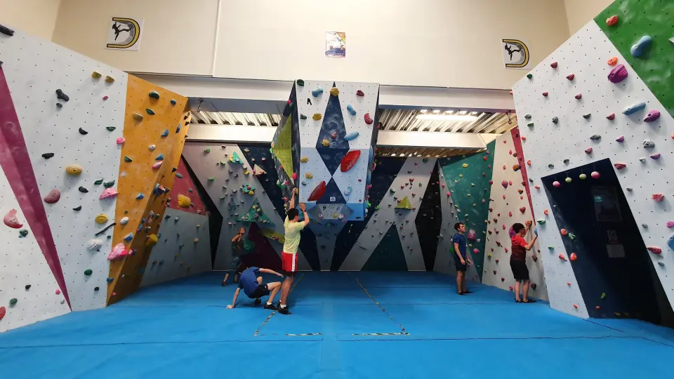 Bouldering area with blue matting and angled walls