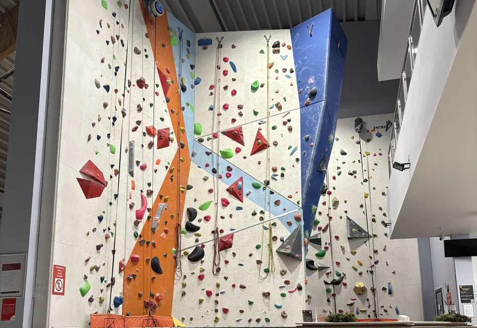 The 7.5m roped wall with orange and blue features and auto-belays