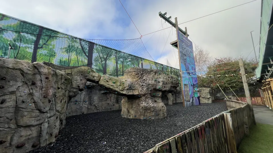 Row of artificial rock boulders in front of a painted forest mural