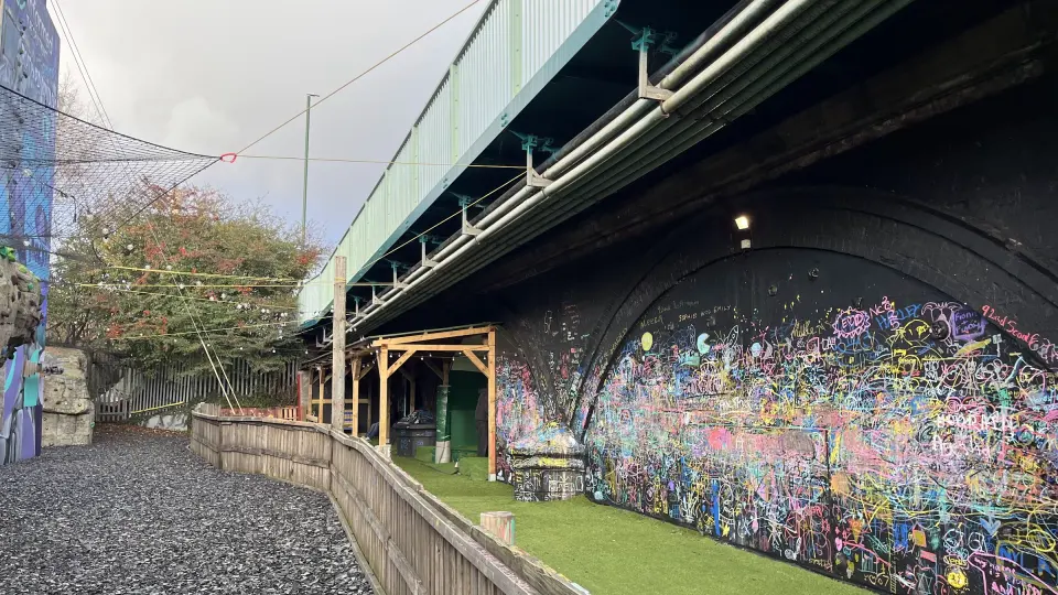 Chalk graffiti wall under the bridge arch beside the boulders