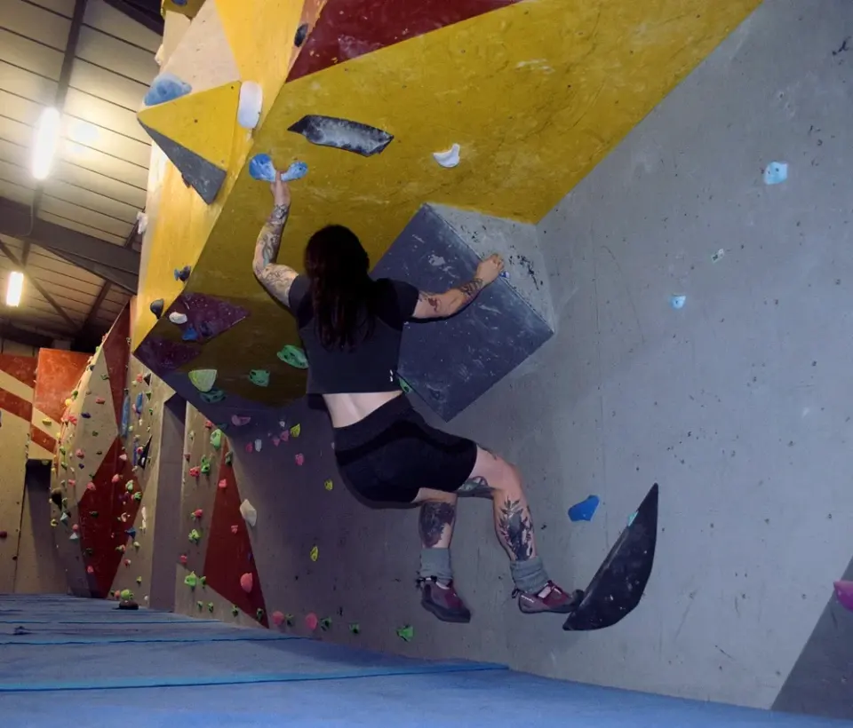 Climber on the steep yellow and red overhang in the bouldering area