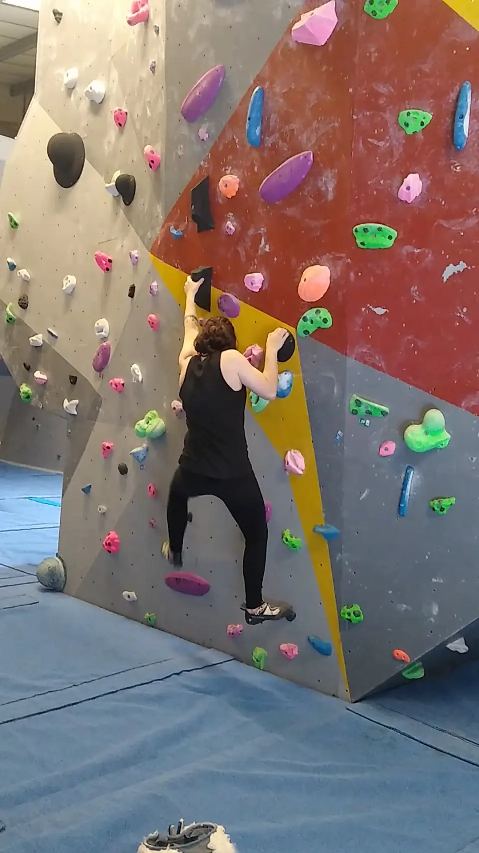 Climber on a red and yellow bouldering wall