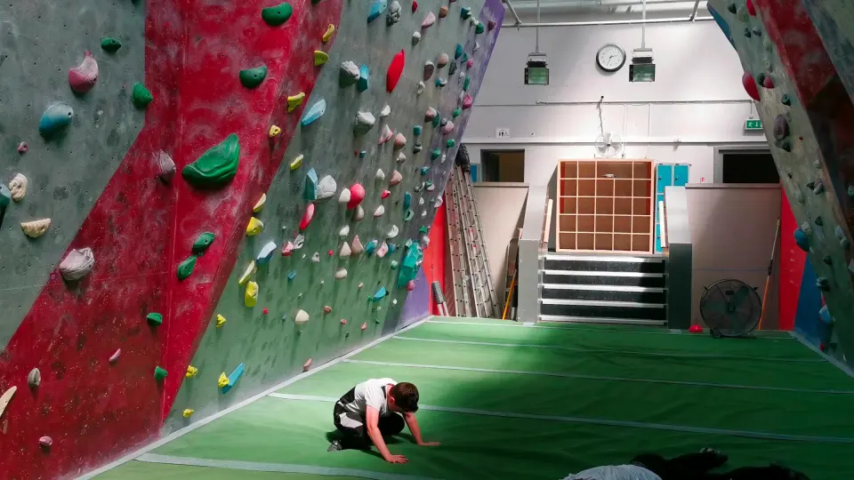 Long bouldering walls either side of the matted pool floor
