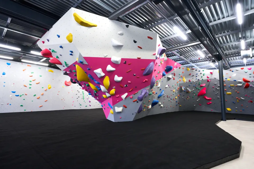 Pink and white feature boulder in the middle of the bouldering hall