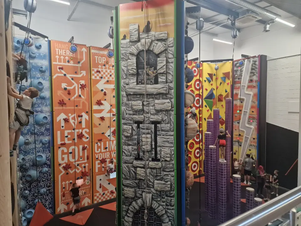 Castle tower wall between bubble-hold and arrow-themed auto-belay walls